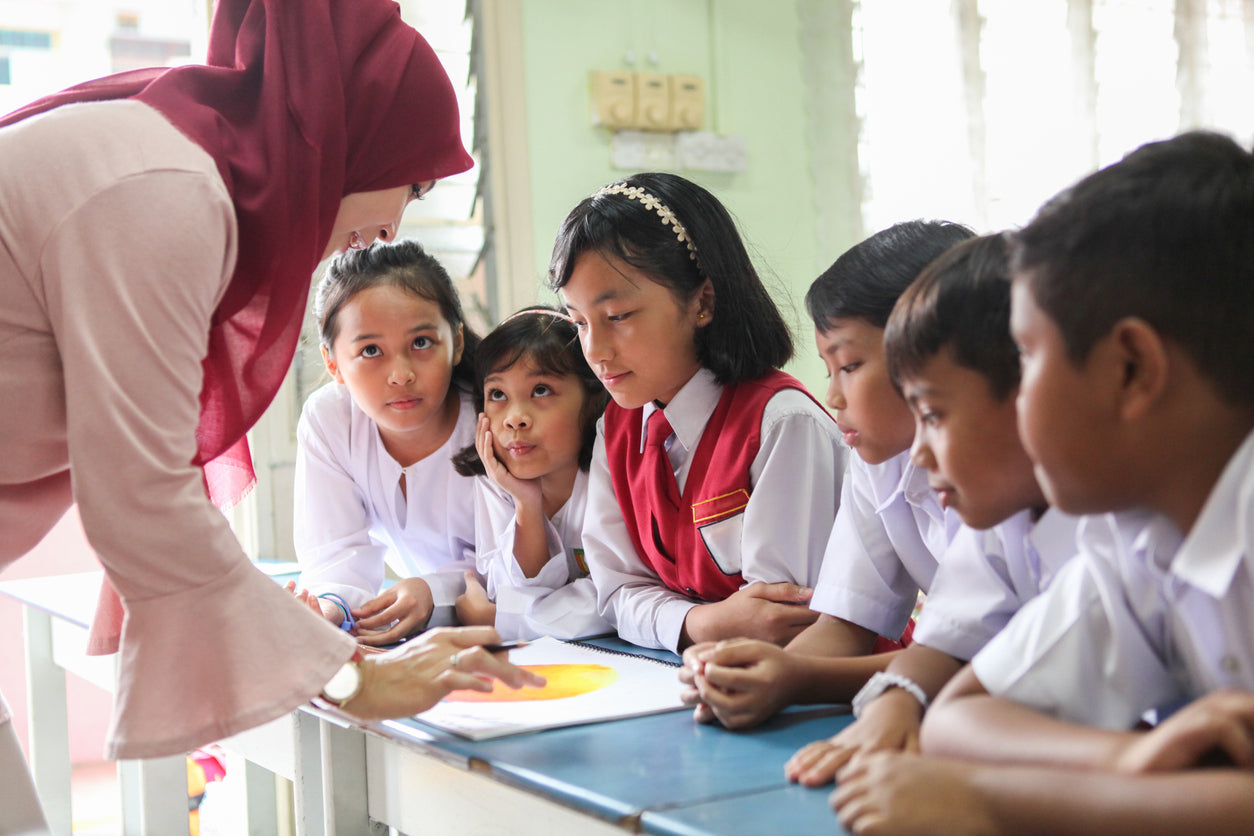Teacher using adaptive teaching strategies in a primary classroom