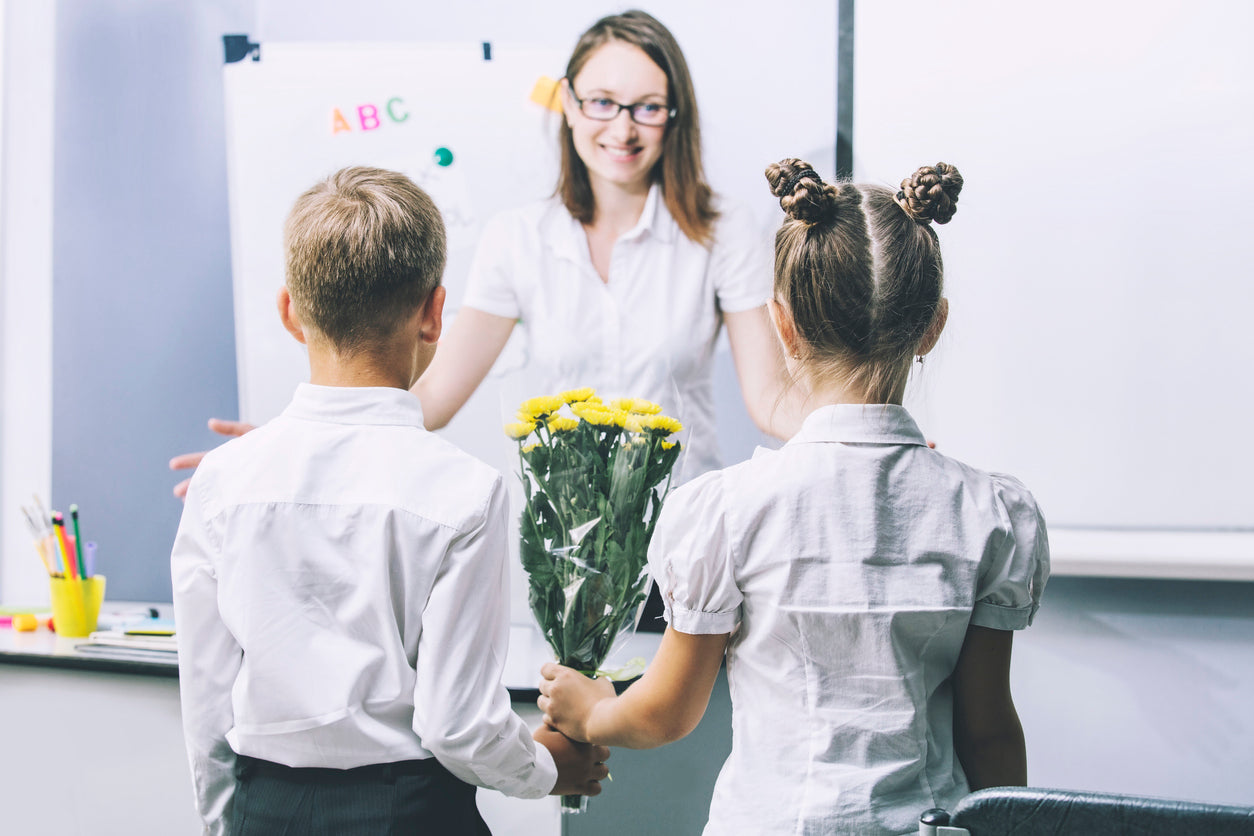 Primary children giving their teacher a gift