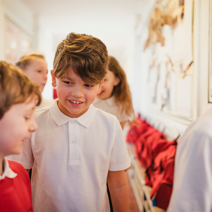 What Makes a Good Friend primary school children in a school hallway
